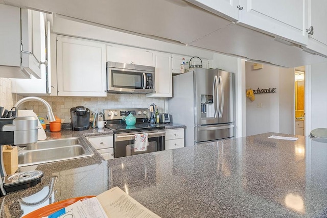 16841 Heritage Bay Rd Unit E-4, Rogers, AR 72756 - kitchen featuring appliances with stainless steel finishes, dark countertops, tasteful backsplash, and white cabinets