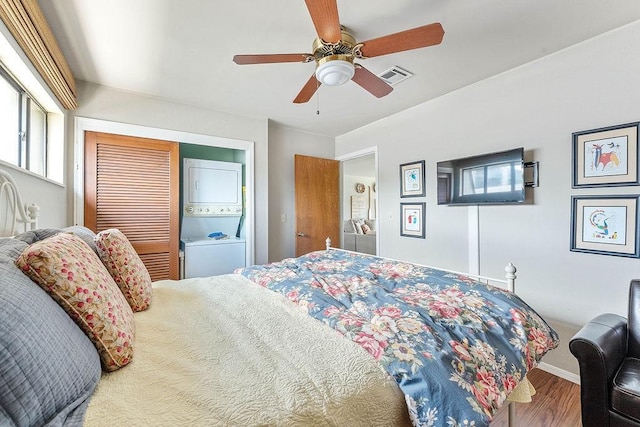 16841 Heritage Bay Rd Unit E-4, Rogers, AR 72756 - bedroom with estacked washer and dryer, wood finished floors, ceiling fan, and a closet