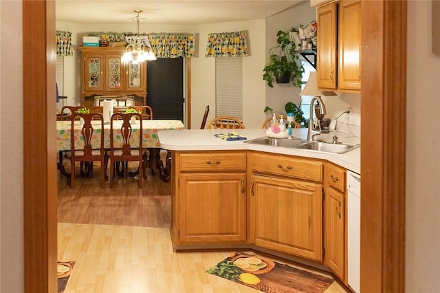 1013 N 26th St, Rogers, AR 72756 - kitchen with a peninsula, light wood-style floors, light countertops, dishwasher, and pendant lighting