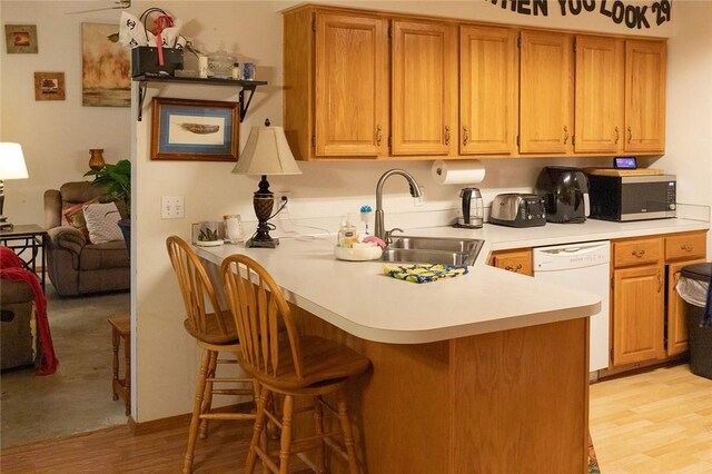 1013 N 26th St, Rogers, AR 72756 - kitchen featuring white dishwasher, stainless steel microwave, a breakfast bar area, a peninsula, and light countertops