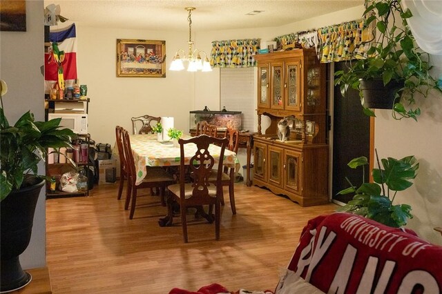 1013 N 26th St, Rogers, AR 72756 - dining room featuring a chandelier and light wood-type flooring