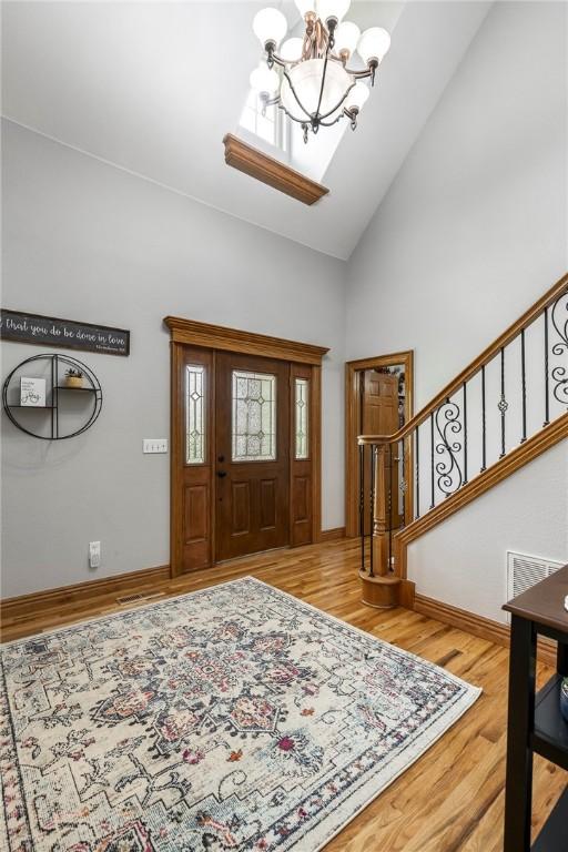 2 Conner Ln, Rogers, AR 72756 - foyer with a chandelier, stairway, high vaulted ceiling, and wood finished floors