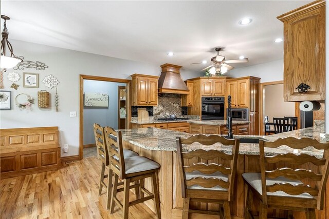 2 Conner Ln, Rogers, AR 72756 - kitchen featuring stainless steel appliances, custom range hood, a ceiling fan, decorative backsplash, and light stone counters