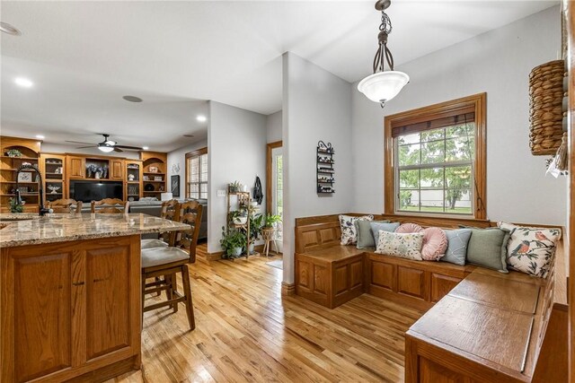 2 Conner Ln, Rogers, AR 72756 - kitchen with open floor plan, light wood-style floors, a kitchen bar, hanging light fixtures, and a ceiling fan