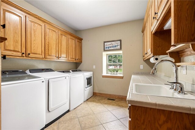 2 Conner Ln, Rogers, AR 72756 - washroom with washing machine and dryer, cabinet space, and light tile patterned floors