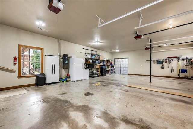 2 Conner Ln, Rogers, AR 72756 - garage featuring freestanding refrigerator and a garage door opener