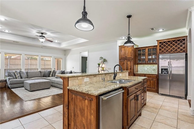 5100 SW Blaire Mont Rd, Bentonville, AR 72713 - kitchen with stainless steel appliances, light tile patterned floors, decorative backsplash, hanging light fixtures, and ornamental molding