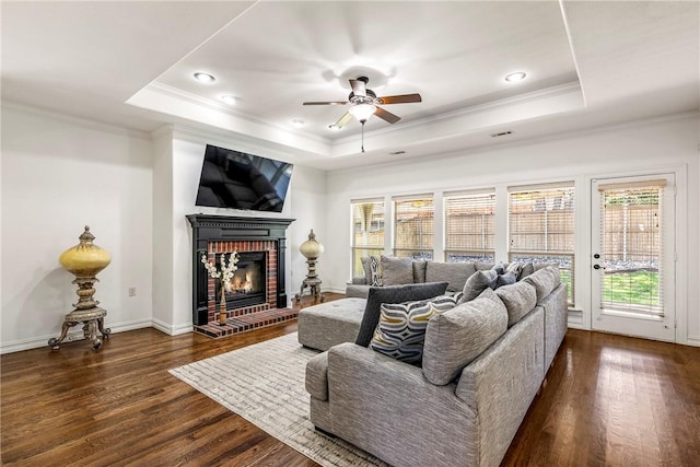 5100 SW Blaire Mont Rd, Bentonville, AR 72713 - living area featuring ornamental molding, a raised ceiling, dark wood-style flooring, a brick fireplace, and ceiling fan