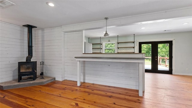 234 N Kibler Hwy, Alma, AR 72921 - unfurnished living room with wood-type flooring, a wood stove, french doors, and recessed lighting