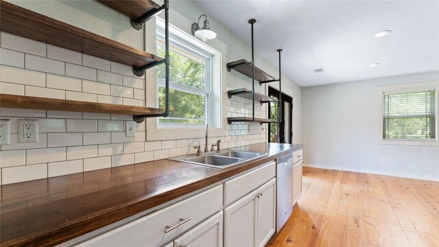 234 N Kibler Hwy, Alma, AR 72921 - kitchen with open shelves, stainless steel dishwasher, dark countertops, light wood-style flooring, and backsplash