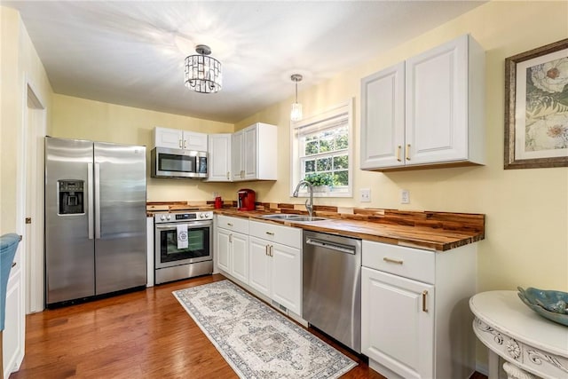 16101 Hickory Dr, Rogers, AR 72756 - kitchen with appliances with stainless steel finishes, wooden counters, white cabinetry, dark wood-style floors, and a chandelier