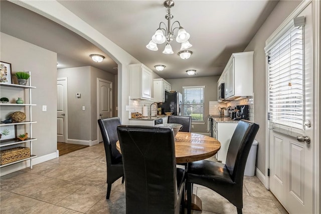 3900 SW Capstone Ave, Bentonville, AR 72712 - dining room with arched walkways, a chandelier, and light tile patterned floors