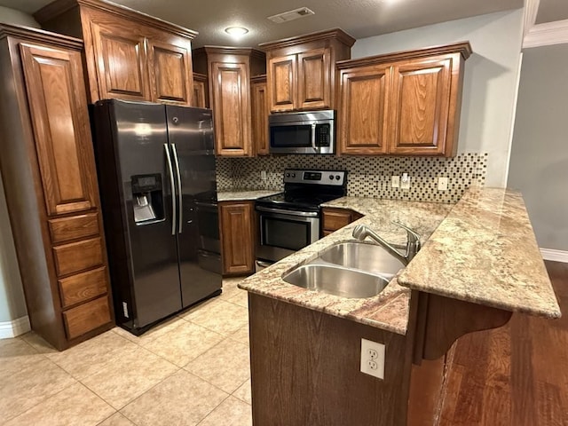 3115 SW Warberry Ave, Bentonville, AR 72713 - kitchen with appliances with stainless steel finishes, a peninsula, tasteful backsplash, light stone countertops, and crown molding