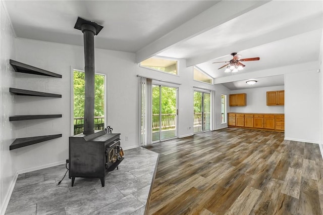 4 Orr Ln, Bella Vista, AR 72715 - living room featuring a wood stove, plenty of natural light, ceiling fan, and dark wood-style floors