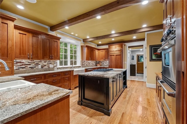 150 Jackson Cove Cres, Eureka Springs, AR 72631 - kitchen featuring light wood-style flooring, beam ceiling, backsplash, brown cabinets, and light stone counters