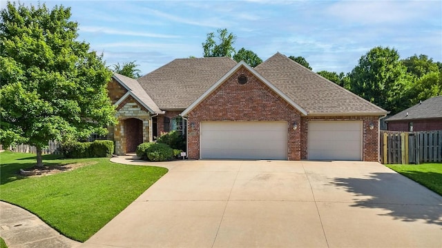 216 Windsor Ave, Lowell, AR 72745 - view of front facade with a garage, concrete driveway, brick siding, a shingled roof, and stone siding