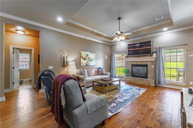 216 Windsor Ave, Lowell, AR 72745 - living room featuring a raised ceiling, wood-type flooring, a ceiling fan, plenty of natural light, and ornamental molding