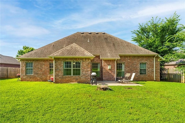 216 Windsor Ave, Lowell, AR 72745 - back of property with a fenced backyard, a patio area, roof with shingles, and brick siding