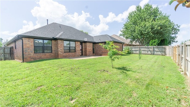 404 NE Whitney St, Bentonville, AR 72712 - back of property featuring a fenced backyard, brick siding, a patio, and a shingled roof