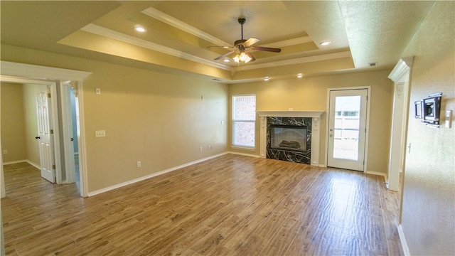 404 NE Whitney St, Bentonville, AR 72712 - unfurnished living room featuring a raised ceiling, crown molding, ceiling fan, plenty of natural light, and a premium fireplace