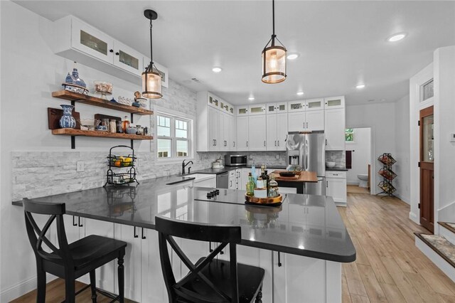 1330 S Curtis Ave, Pea Ridge, AR 72751 - kitchen featuring a peninsula, stainless steel appliances, decorative backsplash, dark countertops, and white cabinets