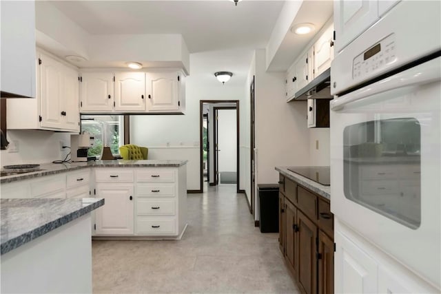 8173 Spanker Creek Rd, Bentonville, AR 72712 - kitchen with white oven, under cabinet range hood, white cabinetry, black electric cooktop, and a peninsula