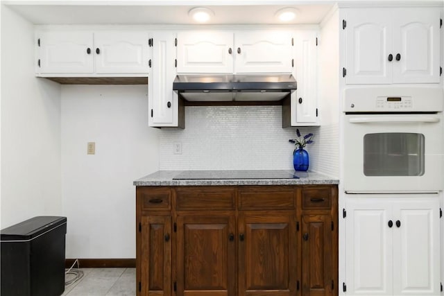 8173 Spanker Creek Rd, Bentonville, AR 72712 - kitchen with oven, under cabinet range hood, backsplash, and black electric stovetop