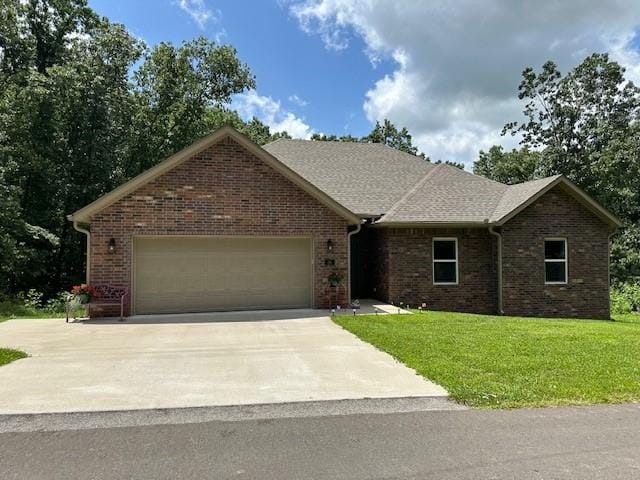 26 Osborne Dr, Bella Vista, AR 72715 - view of front of property with an attached garage, driveway, a front yard, and brick siding
