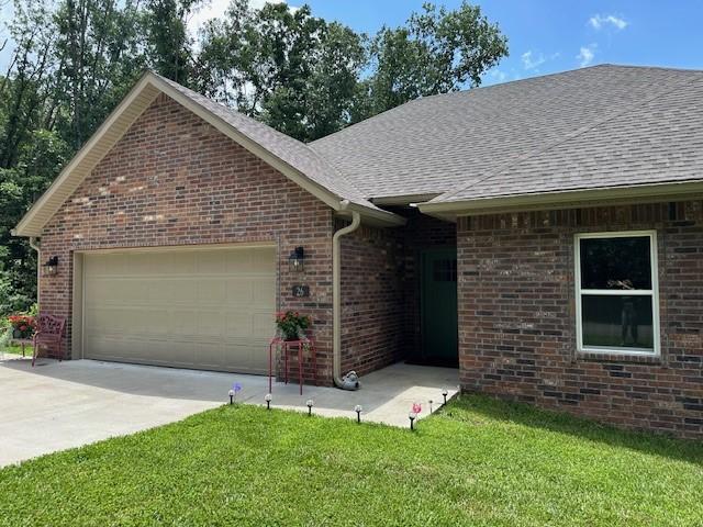 26 Osborne Dr, Bella Vista, AR 72715 - single story home with a garage, a shingled roof, driveway, and a front lawn