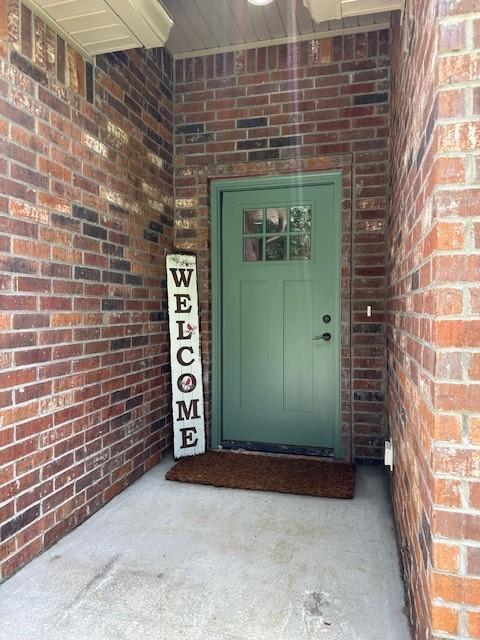 26 Osborne Dr, Bella Vista, AR 72715 - view of exterior entry featuring brick siding