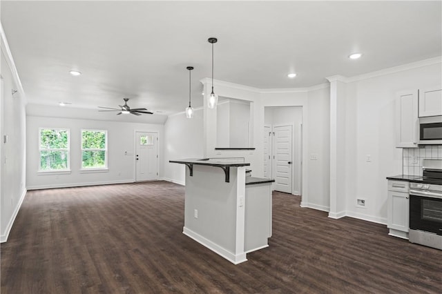 53 Belgravia Dr, Bella Vista, AR 72715 - kitchen with appliances with stainless steel finishes, dark countertops, dark wood-style floors, a kitchen bar, and recessed lighting