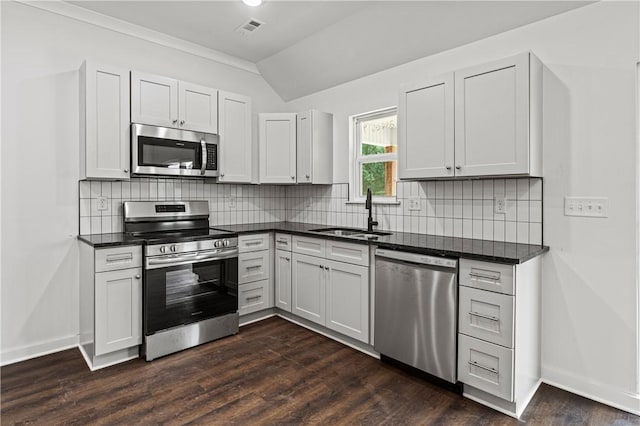 53 Belgravia Dr, Bella Vista, AR 72715 - kitchen with appliances with stainless steel finishes, dark countertops, vaulted ceiling, backsplash, and dark wood-style flooring