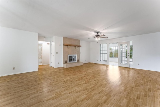 1206 Tru Ln, Rogers, AR 72756 - unfurnished living room featuring a ceiling fan, light wood-style flooring, and a fireplace