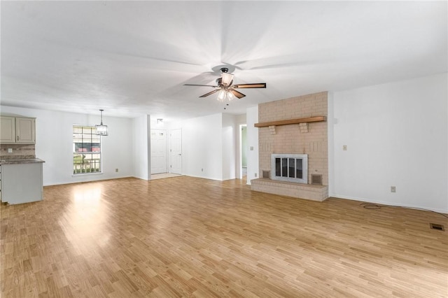 1206 Tru Ln, Rogers, AR 72756 - unfurnished living room with ceiling fan, light wood finished floors, and a fireplace