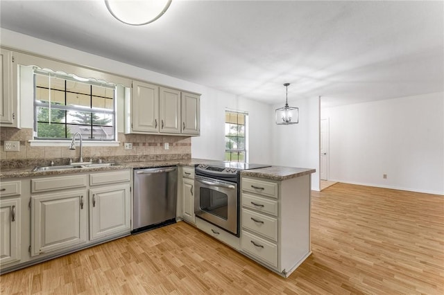 1206 Tru Ln, Rogers, AR 72756 - kitchen featuring appliances with stainless steel finishes, a peninsula, light wood-style flooring, and decorative backsplash