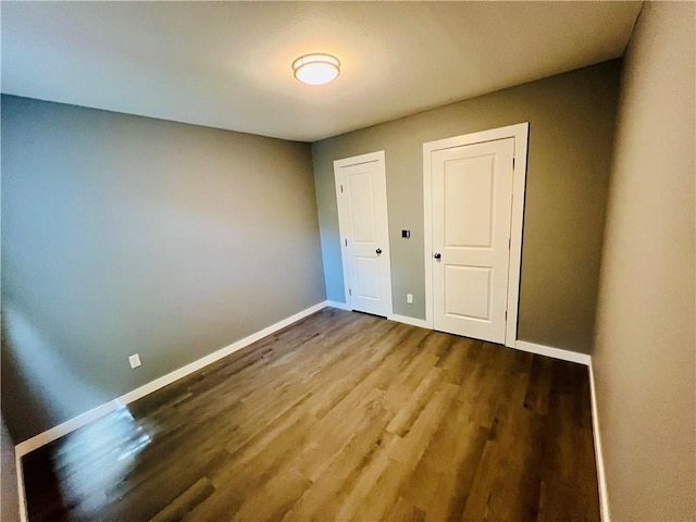 106 Phillips Ave, Huntsville, AR 72740 - unfurnished bedroom with baseboards and wood finished floors