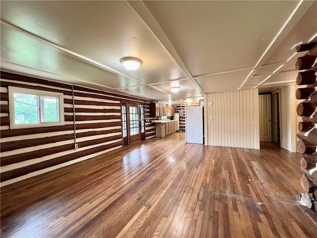 440 N Duff Ave, Sulphur Springs, AR 72768 - unfurnished living room with dark wood finished floors, wooden walls, and french doors