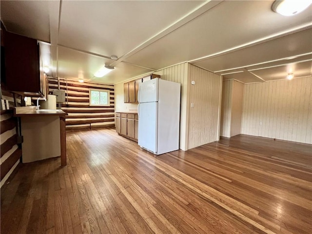 440 N Duff Ave, Sulphur Springs, AR 72768 - kitchen featuring freestanding refrigerator, hardwood / wood-style floors, and wood walls