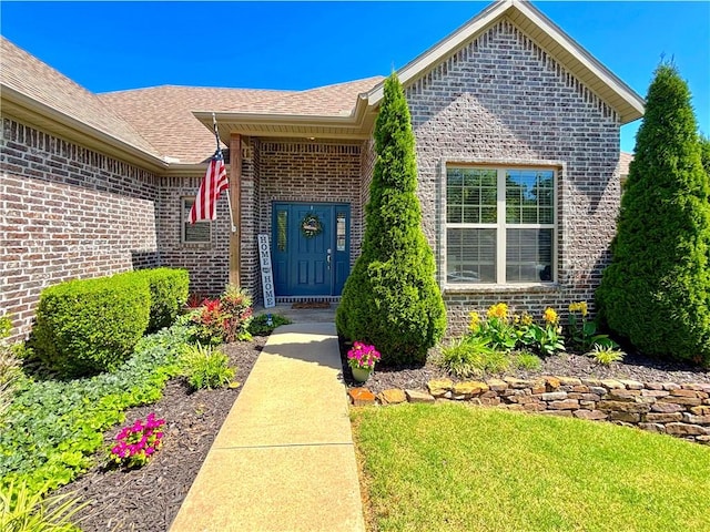 1610 Sweetbriar, Centerton, AR 72719 - property entrance with brick siding, a yard, and a shingled roof