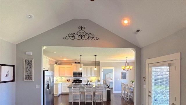 1610 Sweetbriar, Centerton, AR 72719 - kitchen featuring appliances with stainless steel finishes, lofted ceiling, a chandelier, a center island with sink, and decorative light fixtures