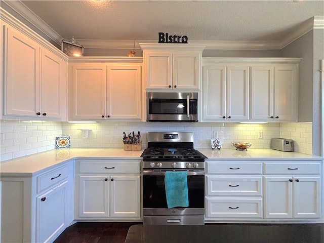1610 Sweetbriar, Centerton, AR 72719 - kitchen featuring appliances with stainless steel finishes, white cabinetry, light countertops, ornamental molding, and a textured ceiling