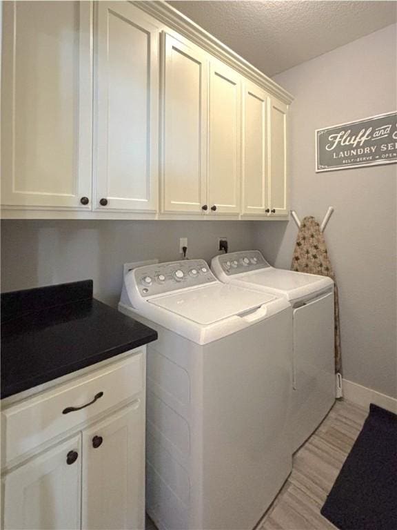 1610 Sweetbriar, Centerton, AR 72719 - laundry area featuring washer and clothes dryer, cabinet space, light wood finished floors, and a textured ceiling