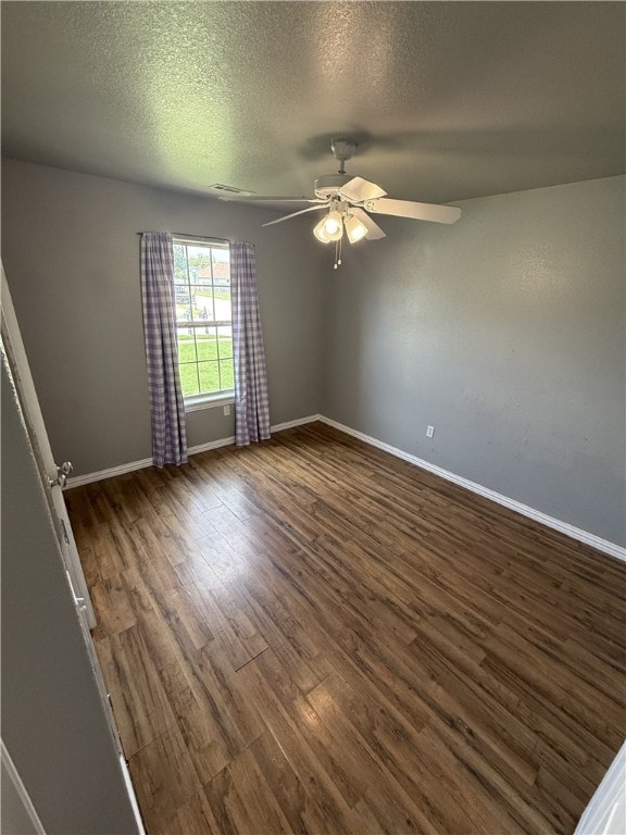 1204 Jim Mcvay, Siloam Springs, AR 72761 - spare room with dark wood-style flooring, a ceiling fan, and a textured ceiling