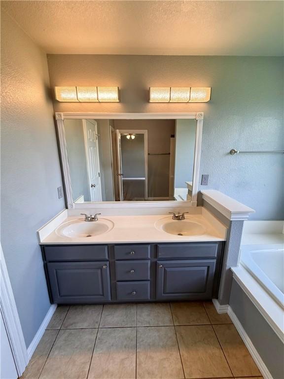 1204 Jim Mcvay, Siloam Springs, AR 72761 - bathroom featuring double vanity, a garden tub, tile patterned floors, and a textured ceiling
