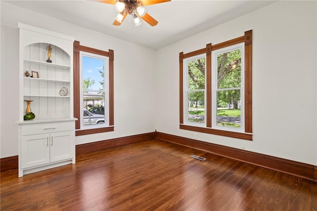 506 E Ashley St, Siloam Springs, AR 72761 - unfurnished room with healthy amount of natural light, dark wood finished floors, and a ceiling fan