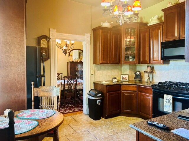 1016 S 4th St, Rogers, AR 72756 - kitchen with a chandelier, black appliances, stone counters, and backsplash