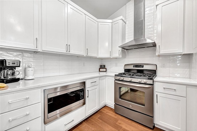 118 Briartown, Bentonville, AR 72712 - kitchen with appliances with stainless steel finishes, wall chimney range hood, light countertops, backsplash, and white cabinetry