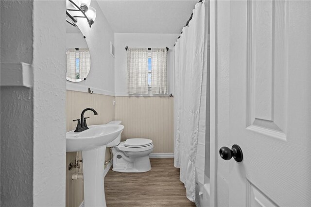 142 N Maple St, Cave Springs, AR 72718 - bathroom with wood finished floors, a wainscoted wall, and shower / bathtub combination with curtain