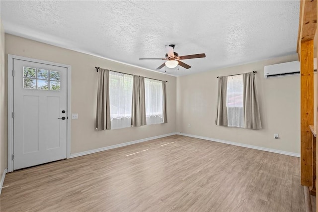 142 N Maple St, Cave Springs, AR 72718 - entryway with a wall unit AC, a textured ceiling, light wood-style flooring, and a ceiling fan