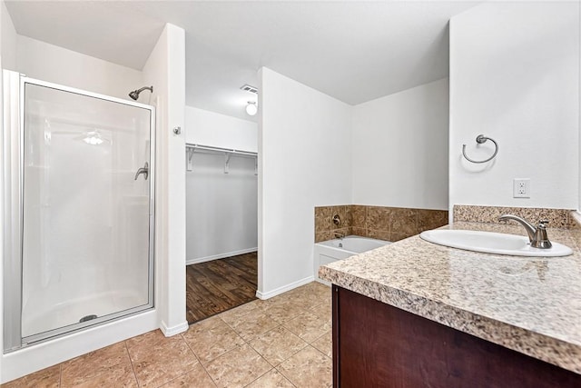 640 Spur Ln, Centerton, AR 72719 - full bath featuring a stall shower, vanity, tile patterned floors, a garden tub, and a spacious closet